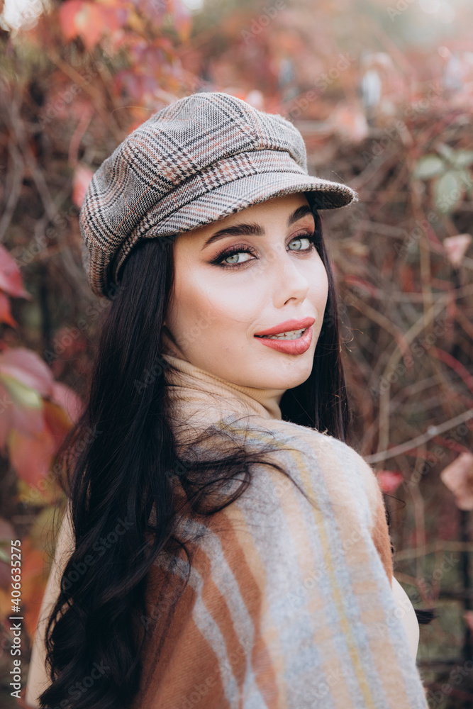 Beautiful and stylish girl model with makeup in a beige dress and a scarf in the form of plaid in the park Beautiful and stylish girl model with makeup in a beige dress and a scarf in the form of plaid in the park