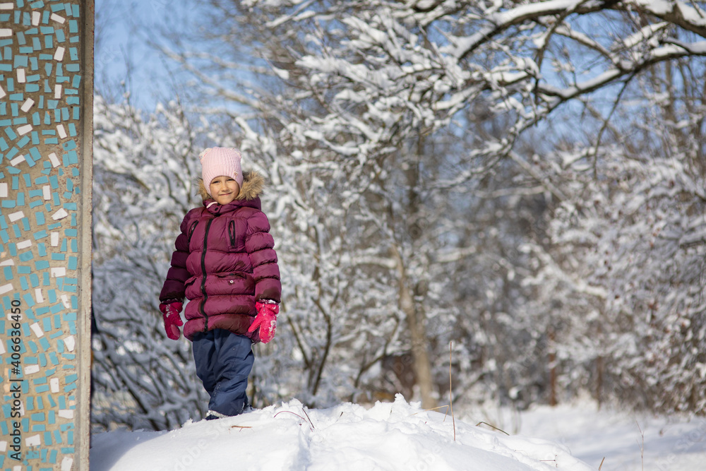 A child girl on a walk in a winter park A child girl on a walk in a winter park