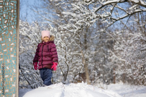 A child girl on a walk in a winter park