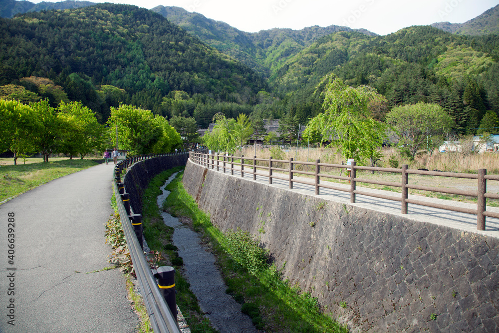 A stream and hills where the traditional village of Saiko Iyashi no Sato Nemba is located near Mount Fuji in Japan.