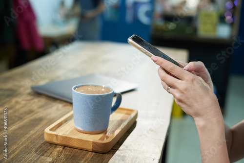 Person takes photos using smartphone of his coffee in mug for blogging