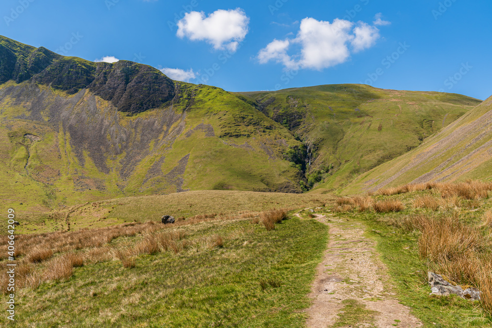 A footpath in the Howgill Fells with Cautley Spout in the background, near Low Haygarth, Cumbria, England, UK A footpath in the Howgill Fells with Cautley Spout in the background, near Low Haygarth, Cumbria, England, UK