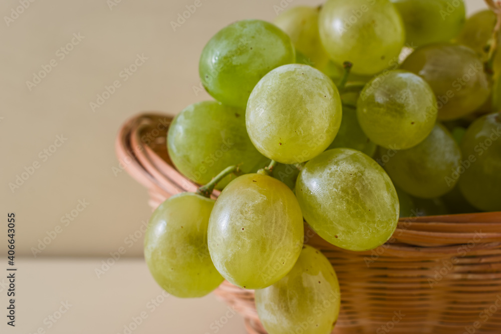 Detail of green grape bunch in a wicker basket. Detail of green grape bunch in a wicker basket.