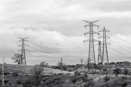 High-voltage towers on the outskirts of town. Black and white.