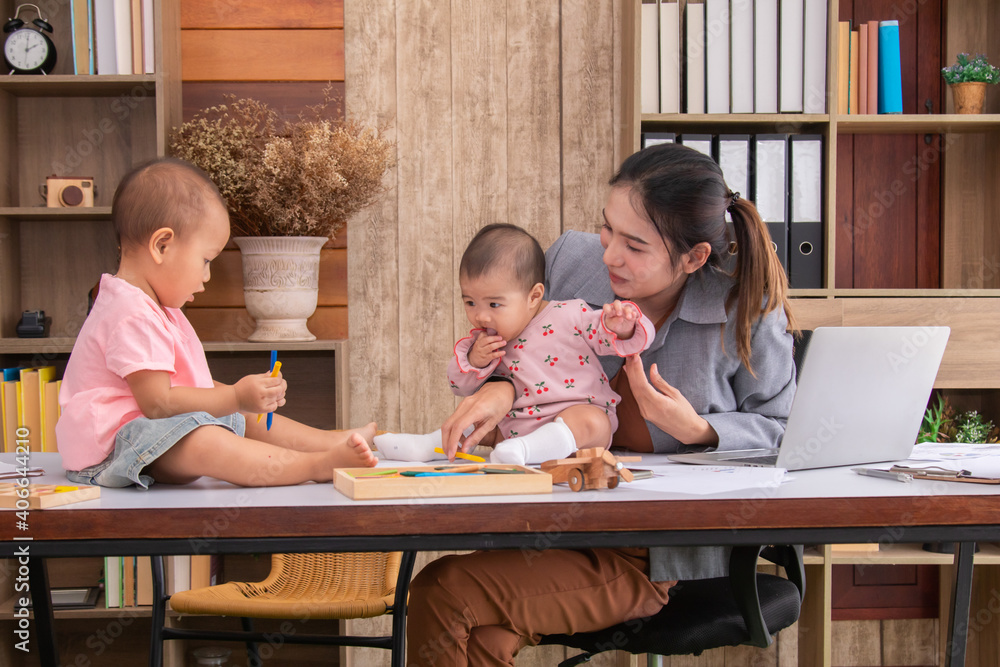 Beautiful Asian mother confuse multi task, single mom cannot work while kids playing, work from home fussy taking care chaotic children in quarantine social distance during Covid-19 crisis concept Beautiful Asian mother confuse multi task, single mom cannot work while kids playing, work from home fussy taking care chaotic children in quarantine social distance during Covid-19 crisis concept