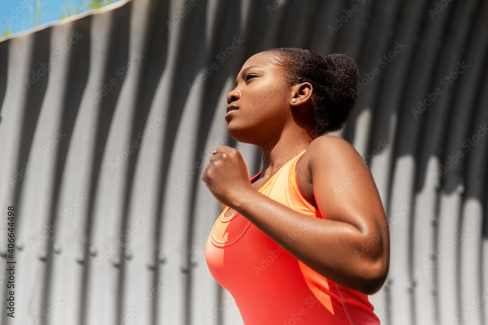 fitness, sport and healthy lifestyle concept - young african american woman running in tunnel fitness, sport and healthy lifestyle concept - young african american woman running in tunnel