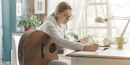 Woman playing guitar and composing music