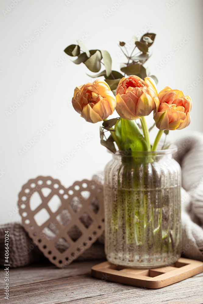 Cozy composition for Valentine's Day with flowers in a vase and a decorative element.