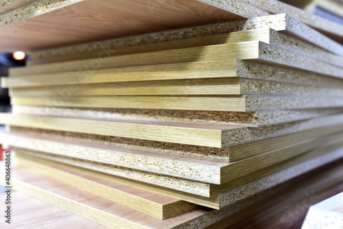 Fragment of a wooden panel made of fiberboard in workshop. Medium Density Fiberboard (MDF). Woodworking industry and furniture assembly concept.