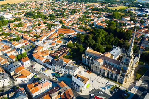 Aerial view of Lucon Cathedral of Notre Dame of Assumption on background of townscape on summer day, Vendee, France..