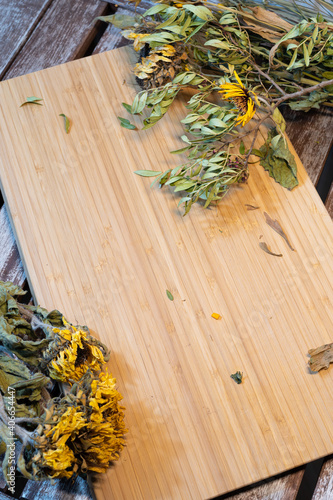 Getrocknete Pflanzen mit Holzbrett auf einen Holztisch.