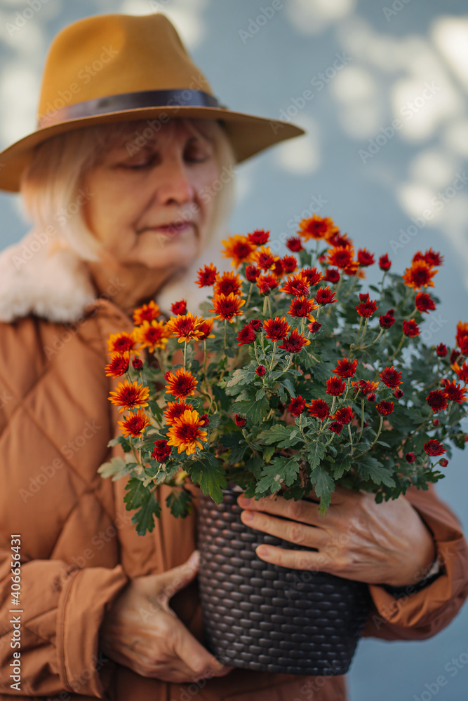 Stylish senior lady with flowerpot