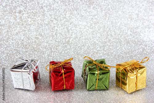 Gifts on a silver glitter background with copy space. Holiday concept, New Year and Christmas background for design.