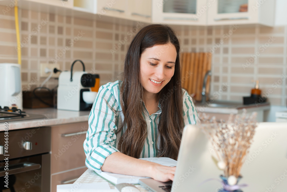 Cheerful young woman in casual working from home at laptop. Cheerful young woman in casual working from home at laptop.