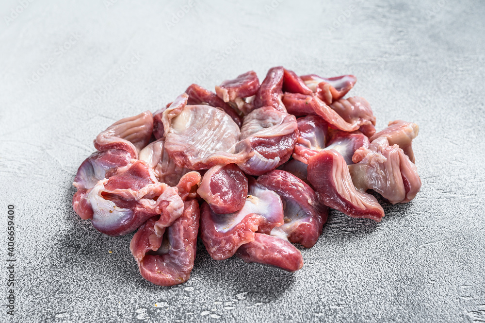 Raw uncooked chicken gizzards, stomach. Gray background. Top view