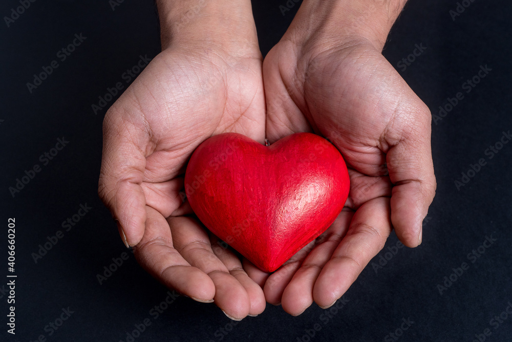 Close up on hands holding a red heart Close up on hands holding a red heart