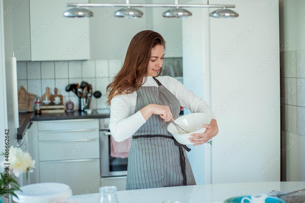 Young beautiful woman bakes a cake. Sweets. Confectionery. Young beautiful woman bakes a cake. Sweets. Confectionery.