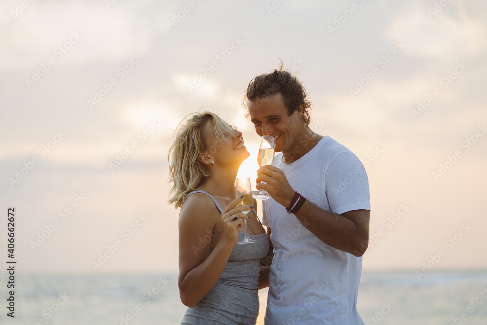 Happy couple drink wine on the sunset beach. Couple in love on sunset background. Valentines day in vacation. Travel, love, youth lifestyle concept. Happy couple drink wine on the sunset beach. Couple in love on sunset background. Valentines day in vacation. Travel, love, youth lifestyle concept.