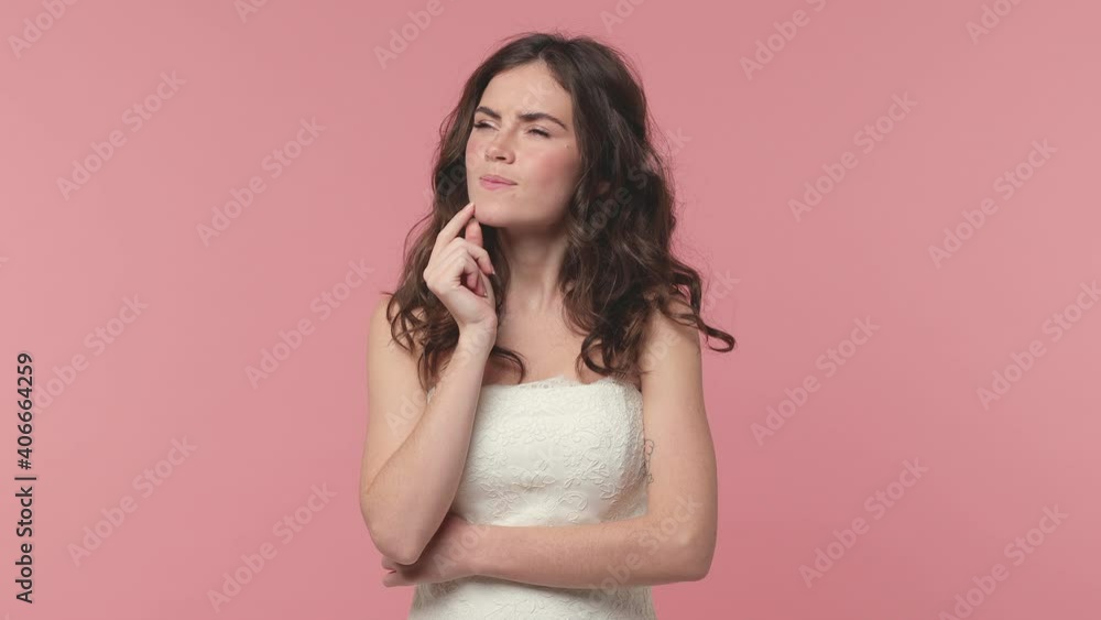 Puzzled excited bride young brunette woman 20s years old in beautiful white wedding dress posing isolated on pink pastel background studio. Wedding concept. Holding index finger up with great new idea Puzzled excited bride young brunette woman 20s years old in beautiful white wedding dress posing isolated on pink pastel background studio. Wedding concept. Holding index finger up with great new idea