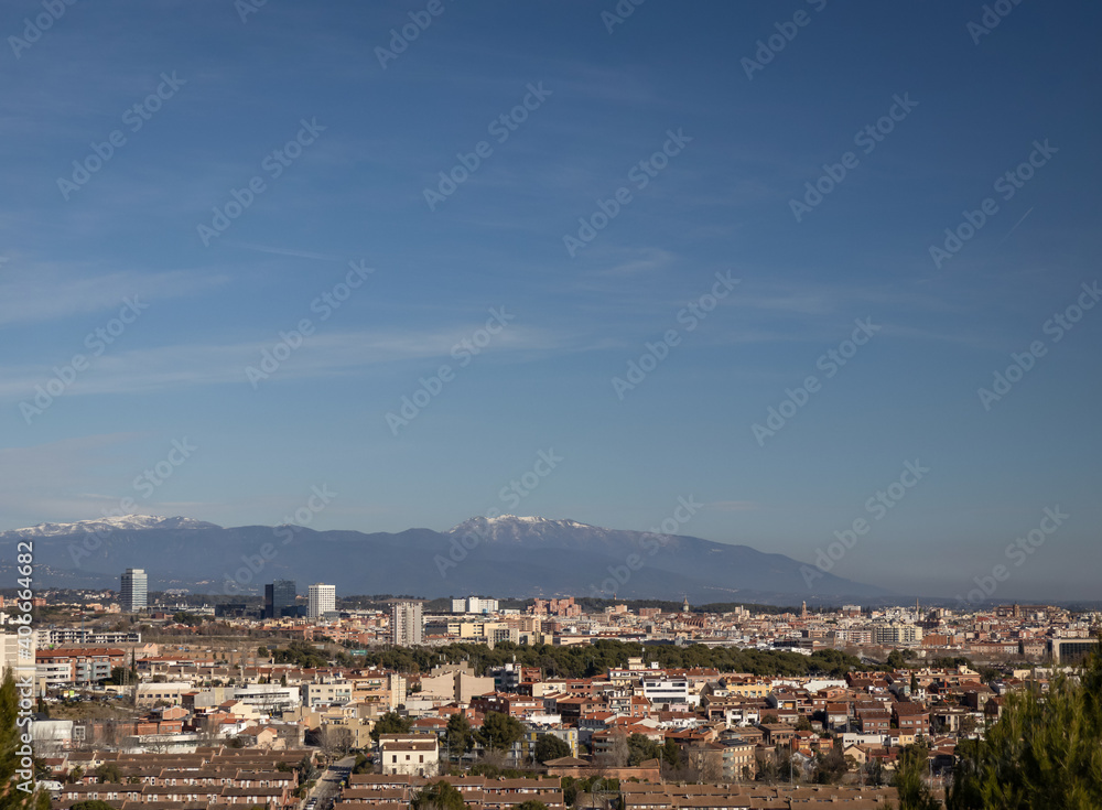 Panoramic view of Sabadell, Spain in winter day with the snowy mountains on horizon.