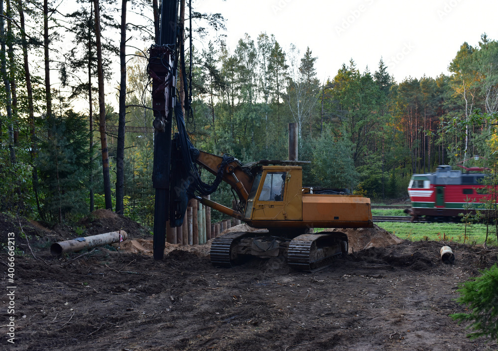 Vibrating hydraulic hammer in forest area. Hydraulically driven free