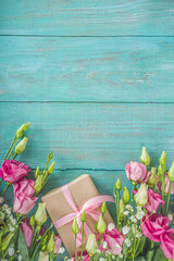 Beautiful spring flowers on light blue wooden background. Festive floral composition with craft paper  gift boxes. Valentine's day, Womans day, mothers day greeting card . Top view flat lay