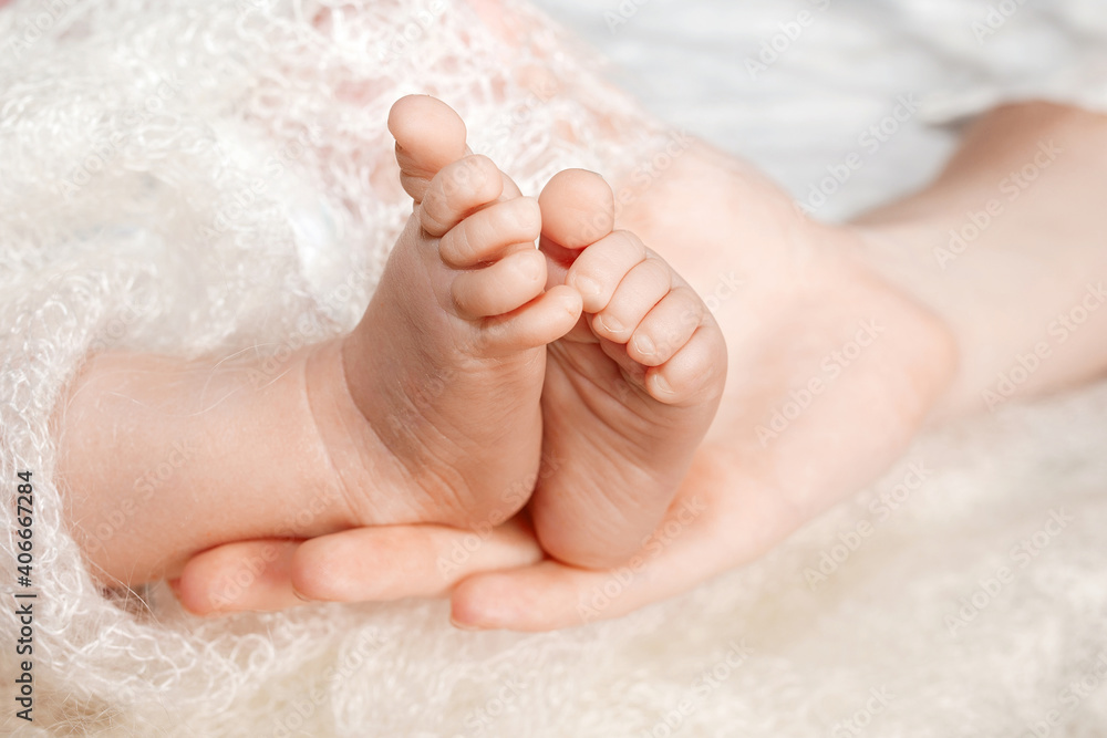 Baby feet in mother hands. Mom and her child. Happy family concept. Beautiful conceptual image of Maternity