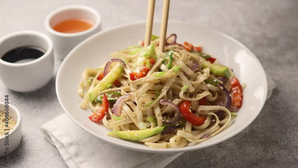 Man twirls rice noodles with chopsticks Man twirls rice noodles with chopsticks