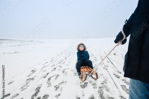 Man pulls a sled with a child on it. Sledging in winter. Germany in winter