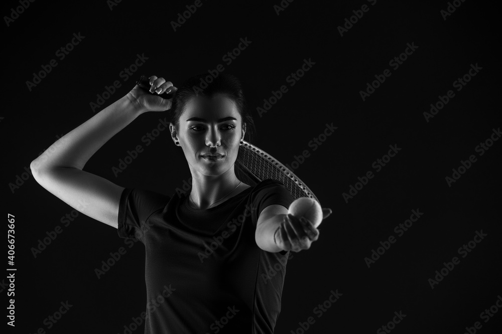 Tennis girl with racket serve ball on dark background. Player doing sport workout online. Sport and recreation concept. Black and white color filter