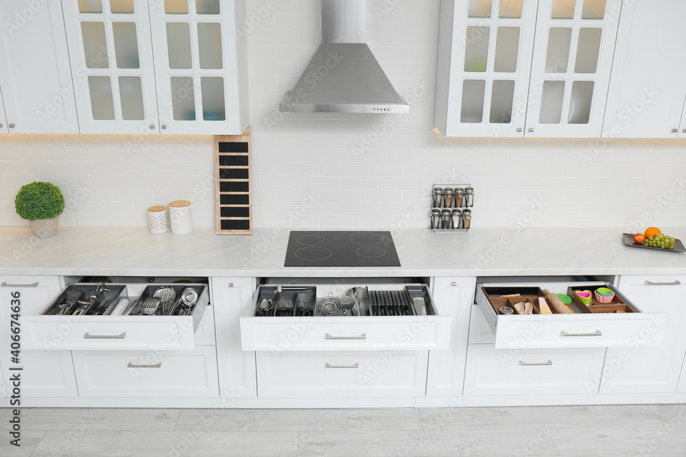 Open drawers with different utensils in kitchen Open drawers with different utensils in kitchen