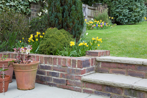 Garden scene with early spring flowers in England, UK