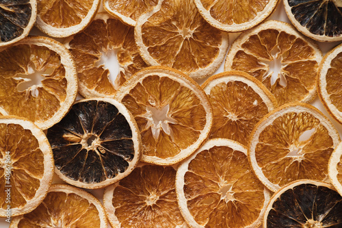 Slices of dried oranges. Raw citrus fruit pattern background. Flat lay, top view.