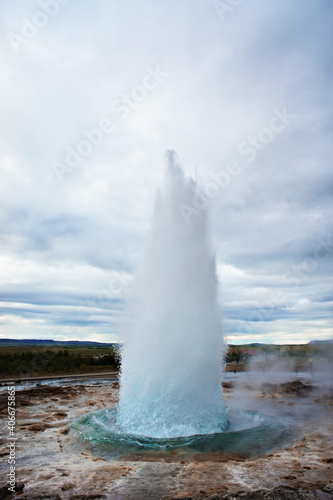 The Great Geysir, geyser in southwestern Iceland, Haukadalur valley, Geyser splashing out of the ground against the background of a cloudy sky, abstract vertical background with water