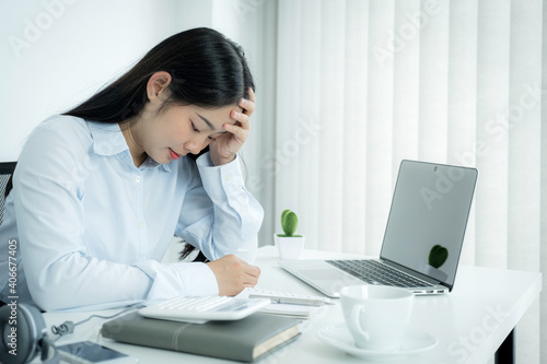 Sad Asian businesswoman employee unhappy working with bored on the laptop and chart in the office tired, Office Syndrome concept