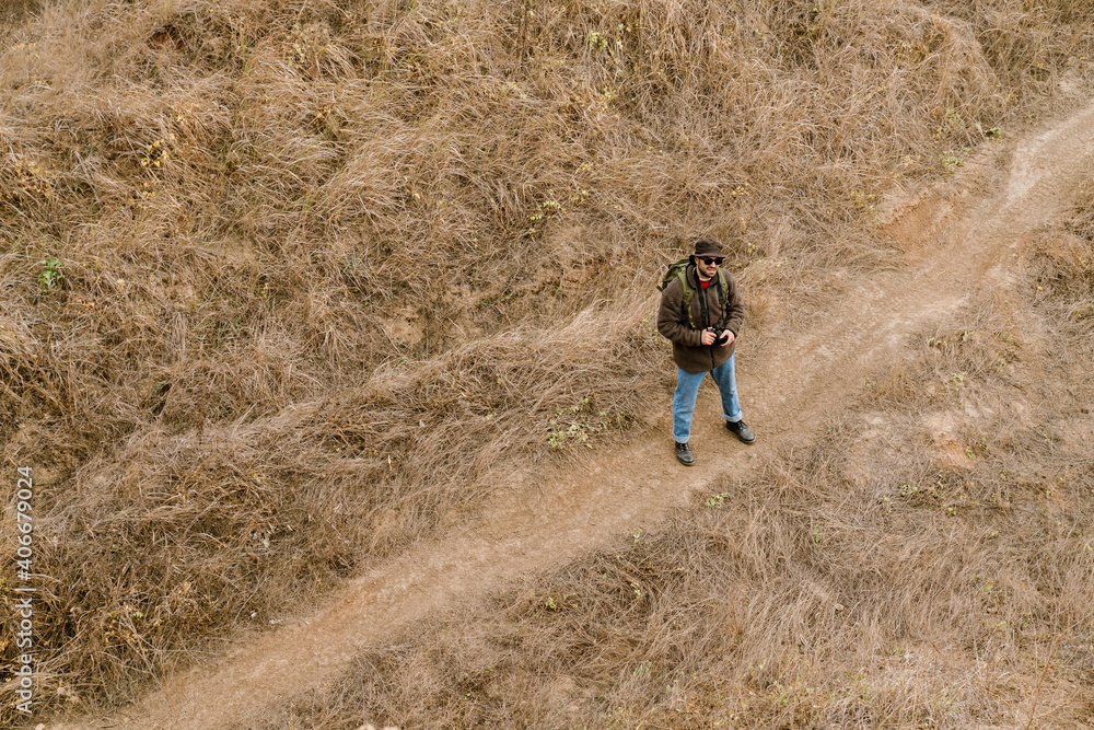 Focused handsome photographer walking with digital camera Focused handsome photographer walking with digital camera