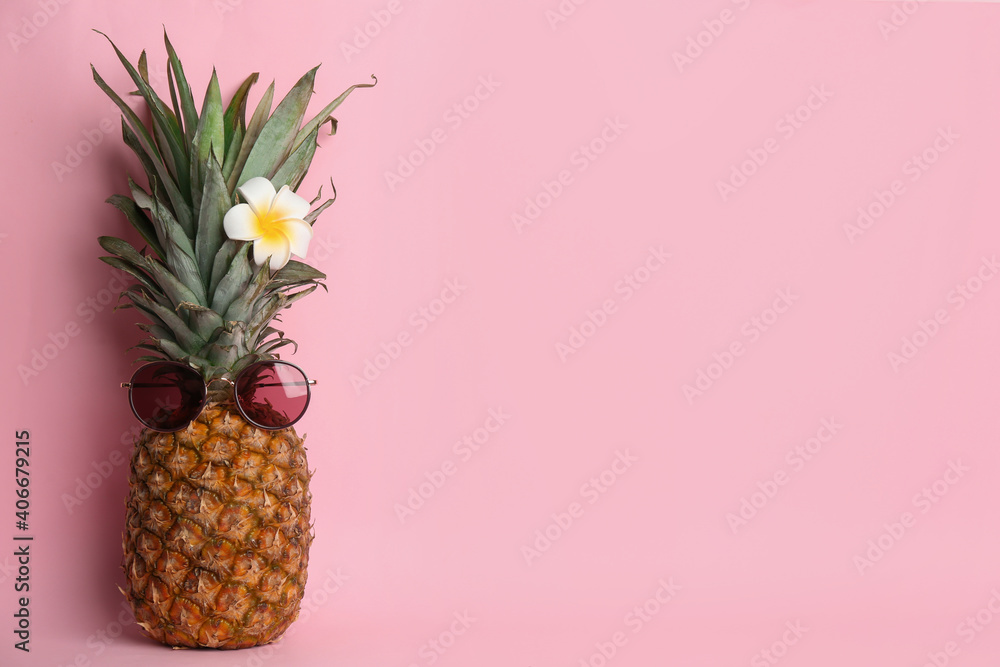 Fototapeta Funny pineapple with sunglasses and plumeria flower on pink background, space for text. Creative concept