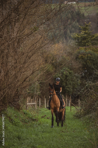 woman riding her brown horse with black mane dressed in black with a helmet © Alvaro Postigo 
