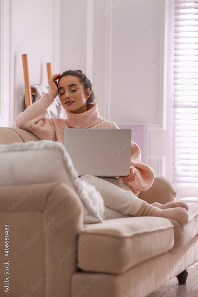 Beautiful young woman with laptop relaxing at home. Cozy atmosphere Beautiful young woman with laptop relaxing at home. Cozy atmosphere