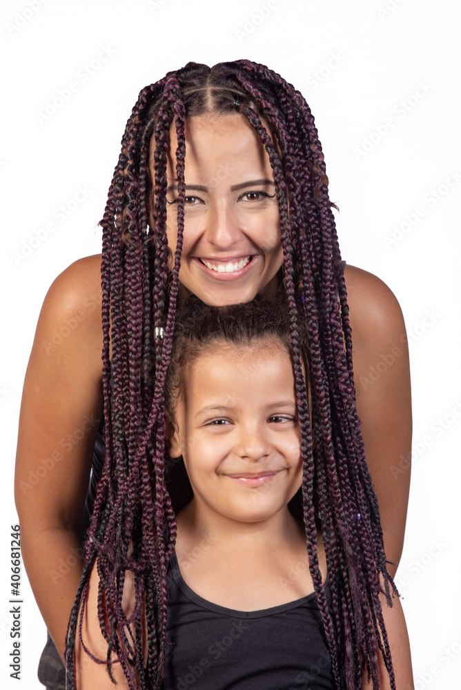 Mother and daughter dressed alike in a very happy shoot, playing with mommy's hair, white background, selective focus. Mother and daughter dressed alike in a very happy shoot, playing with mommy's hair, white background, selective focus.