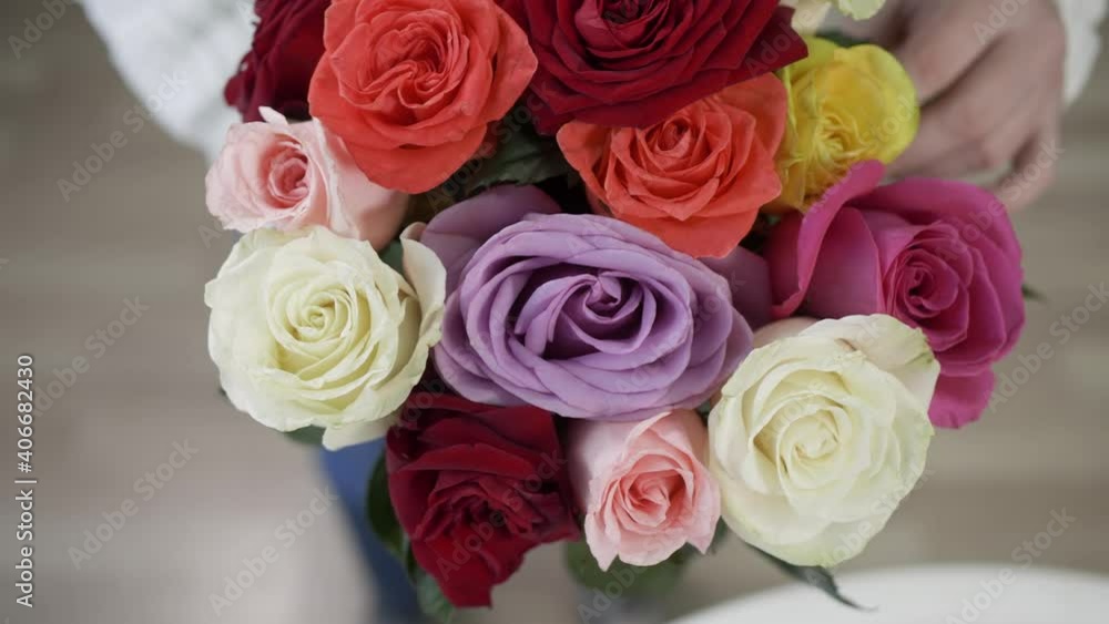 Overhead view of beautiful bright rose bouquet in female hands. Close-up of woman holding amazing colorful roses in flower shop, top view Overhead view of beautiful bright rose bouquet in female hands. Close-up of woman holding amazing colorful roses in flower shop, top view