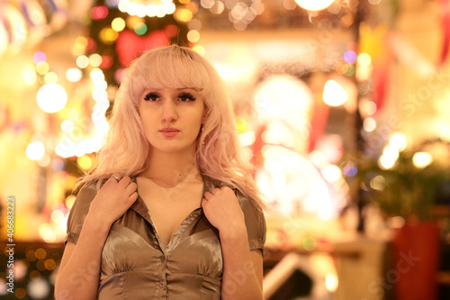 blond woman close up portrait with Christmas illuminated decorations close up photo