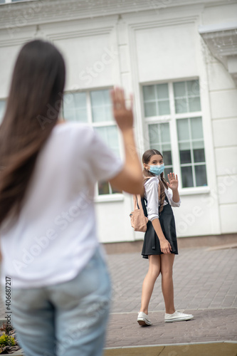 Girl in protective mask near school and mom © zinkevych
