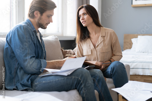 Photo of cheerful young couple analyzing their finances with documents