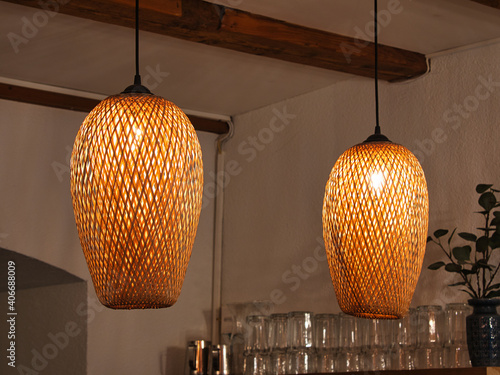 zwei Deckenleuchten aus braunem Rattan, die von der Decke hängen