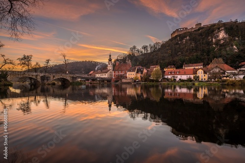 Bild einer Panorama Stadtansicht des Markt Kallmünz Kallmuenz zur blauen Stunde während Sonnenuntergang in Bayern und dem Fluss Naab Vils und der Burg Ruine auf dem Berg, Deutschland