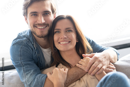 Happy couple or marriage hugging and enjoying in a couch at home.