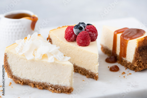 Cheesecake slices with various toppings. Choice of cheesecakes. Caramel sauce, berries and vegan coconut cashew cheesecake