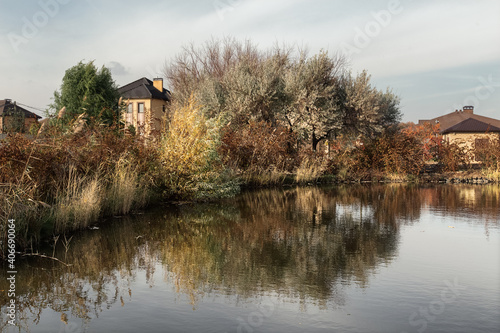 Obraz na płótnie Colorful autumn landscape with pond. Sky white clouds reflection in water and colorful fall trees. Calming water surface. w salonie