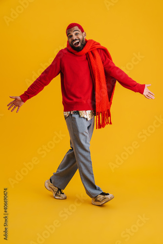 Delighted african american guy walking with throwing up arms